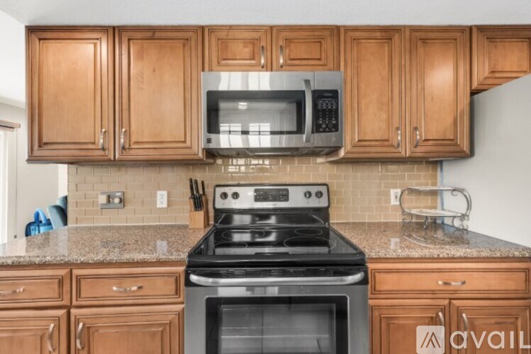 A kitchen with wooden cabinets and a black stove top oven.