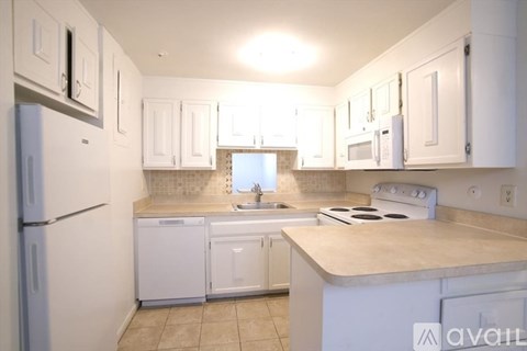 A kitchen with white cabinets and appliances.