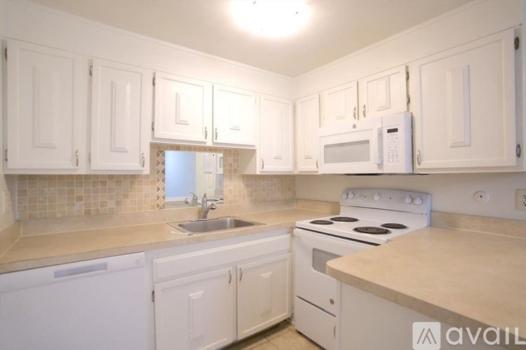A kitchen with white cabinets and appliances.