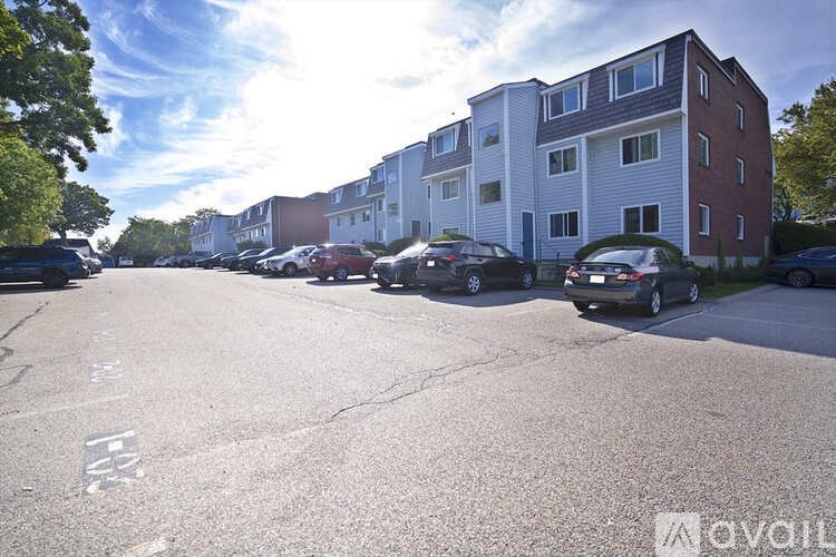 A parking lot with cars and apartment buildings in the background.