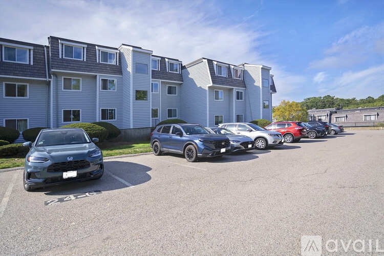 A parking lot with cars and apartment buildings in the background.