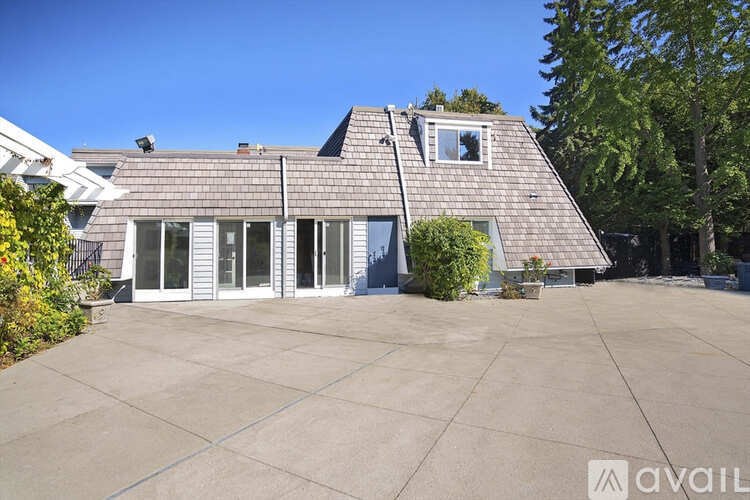 A house with a grey roof and a large driveway.