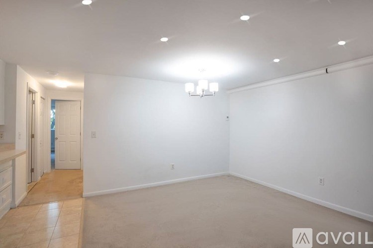A spacious empty room with a doorway leading to another room.