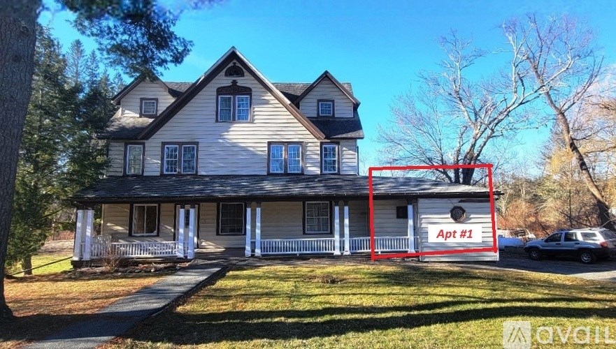A house with a sign that says "Apt #1" in front of it.