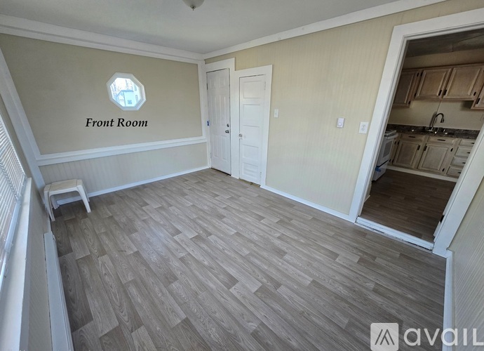 A front room with wooden flooring and a window.