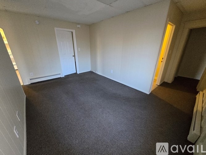 A room with a carpeted floor and a door.