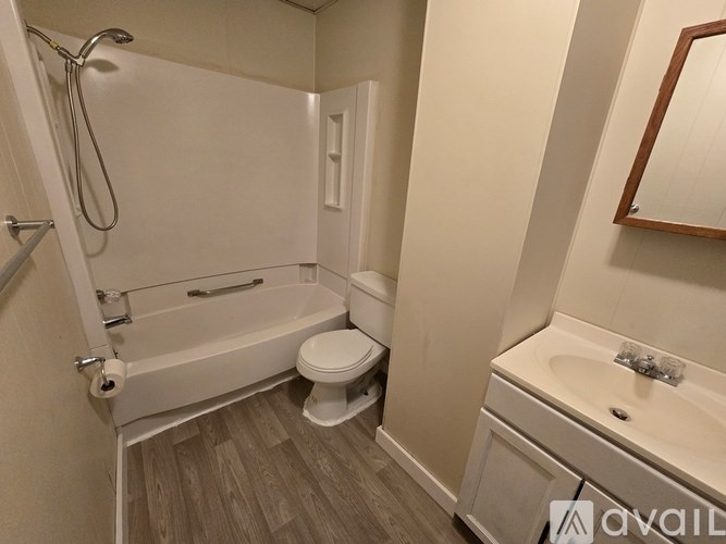 A bathroom with a white tub, toilet, and sink.