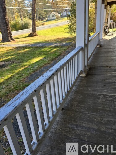 A wooden porch with a white railing.