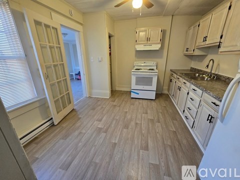 A kitchen with a white stove and cabinets.