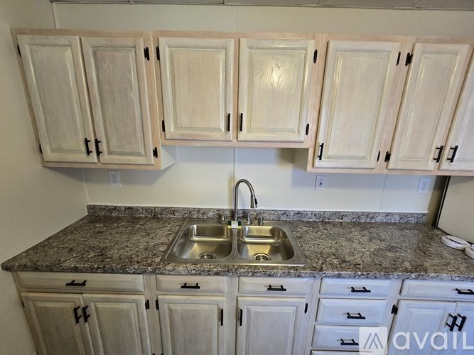 A kitchen with granite countertops and white cabinets.