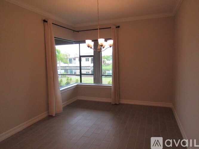 A room with a large window and a hanging light fixture.