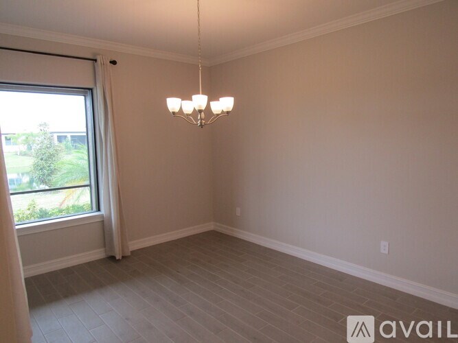 A room with a chandelier and a window with a view of the outdoors.