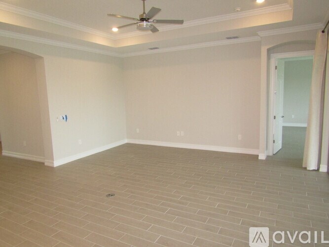 A spacious room with a ceiling fan and tiled flooring.