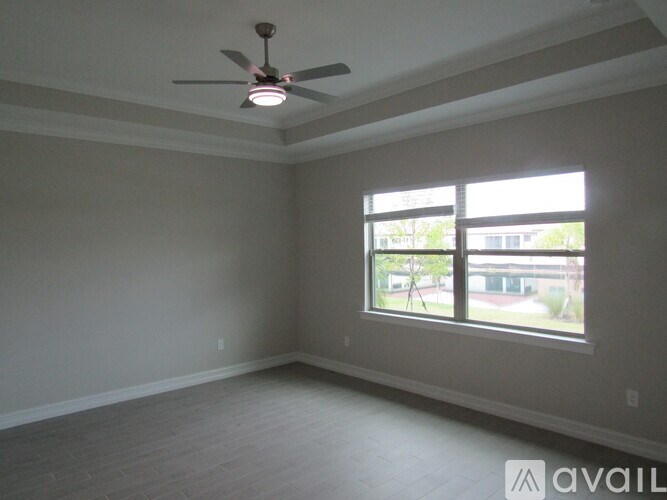 A room with a ceiling fan and a window.
