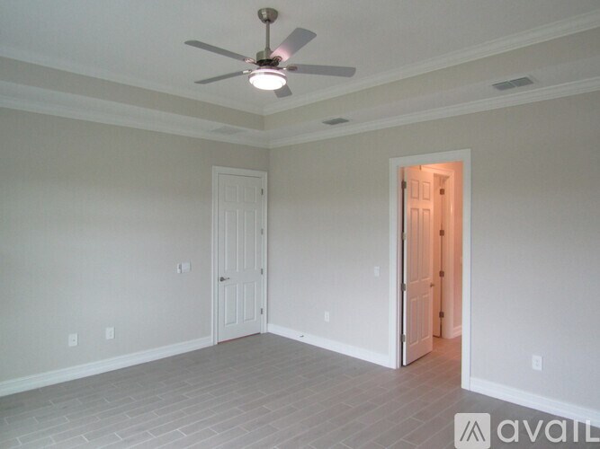 A room with a ceiling fan and two doors.