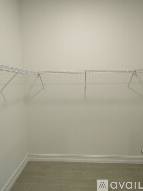 Empty room with a clothes rack and tiled floor.