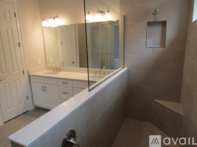 A bathroom with a white vanity and a large mirror.