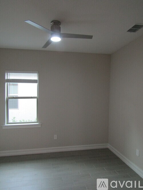 A room with a ceiling fan and a window.