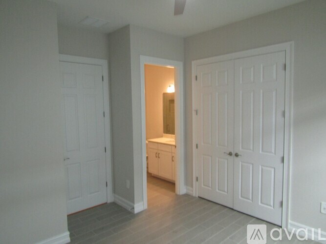A room with a white door and a white cabinet with a light on.