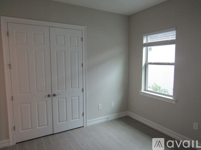 A room with a white door and a window.
