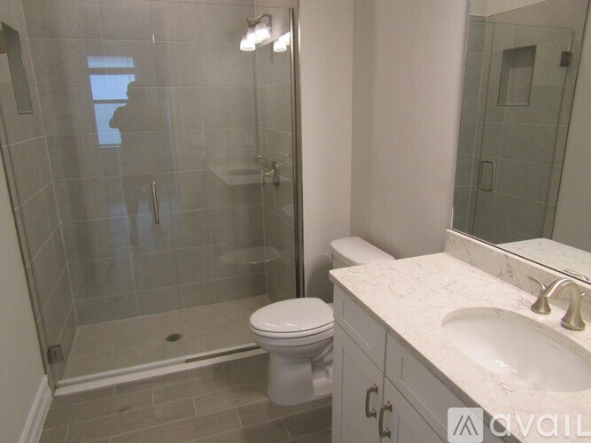 A bathroom with a toilet, sink, and shower.