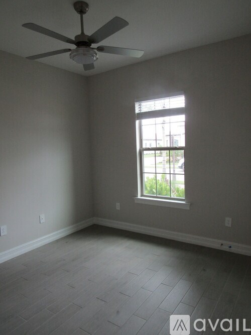 A room with a ceiling fan and a window.