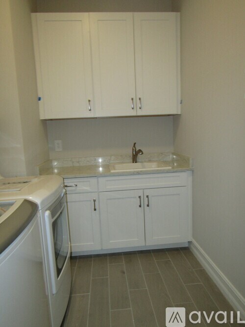 A kitchen with white cabinets and a white dishwasher.
