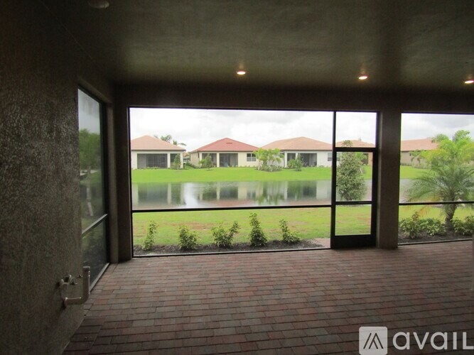 A view from inside a room looking out to a backyard with a fence and houses in the distance.