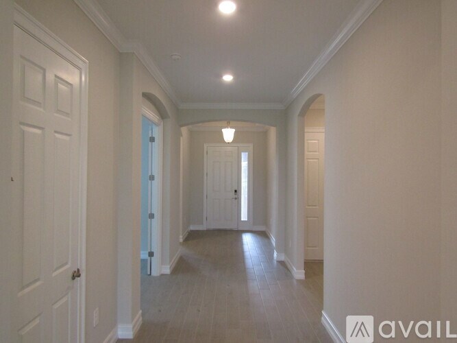 A long hallway with white walls and a light on the ceiling.
