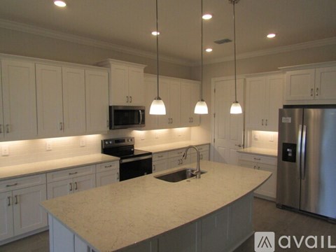 A kitchen with white cabinets and a marble countertop.
