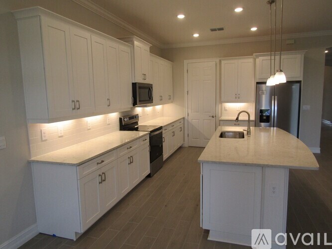 A kitchen with white cabinets and a wooden island.