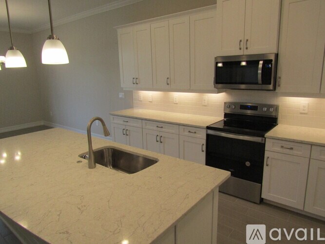 A kitchen with a sink and a microwave.