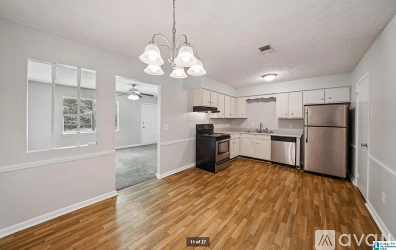 A kitchen with wooden floors and stainless steel appliances.