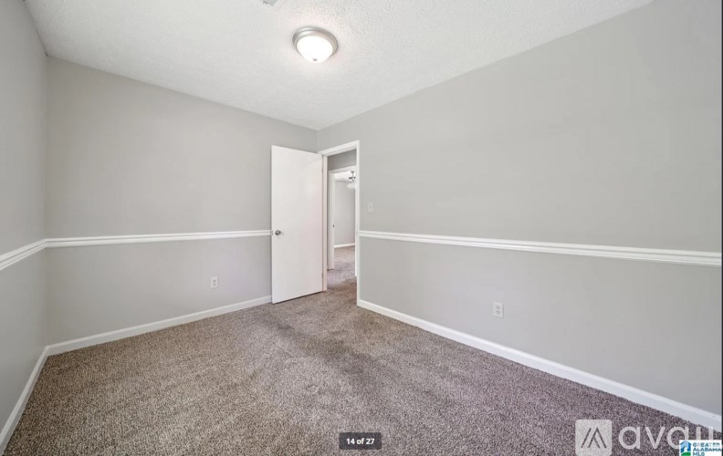 A room with a carpeted floor and a doorway leading to another room.