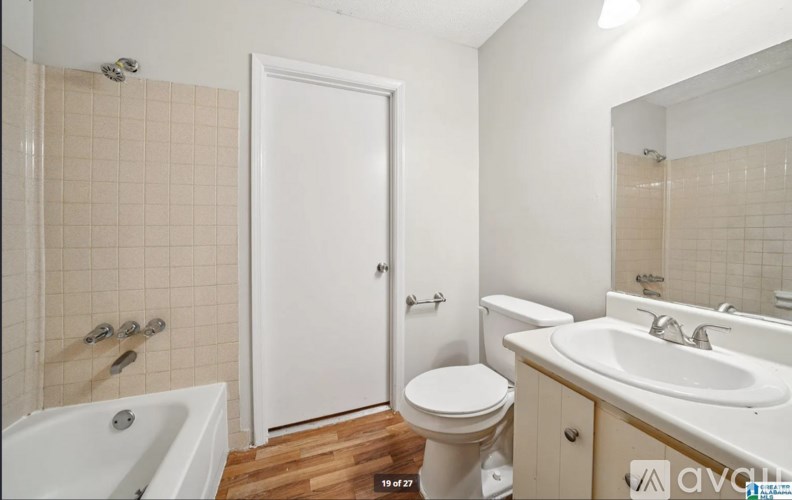 A white bathroom with a toilet, sink, and bathtub.