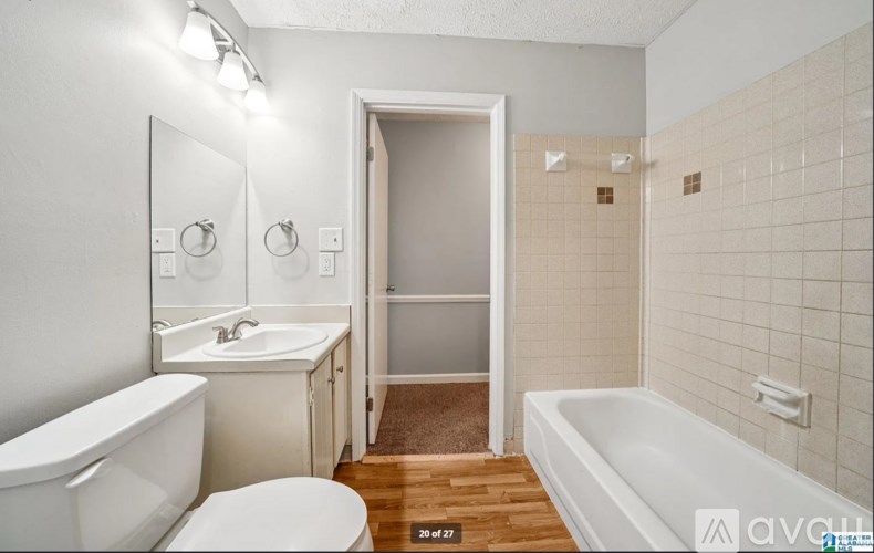 A white bathroom with a tub, toilet, and sink.
