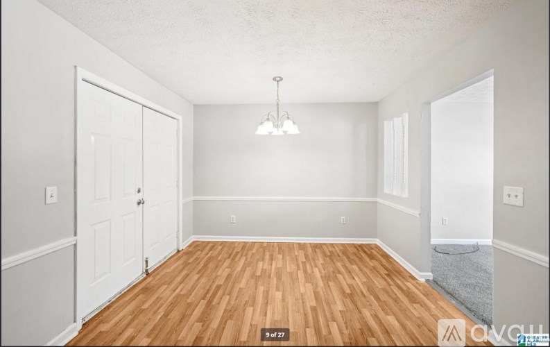 A room with wooden flooring and white walls.