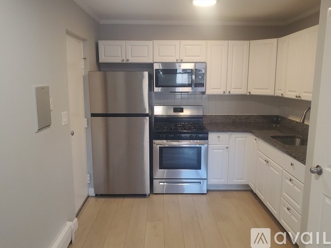 A kitchen with a stainless steel refrigerator, oven, and microwave.
