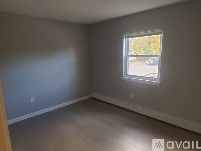 A room with a window and wooden flooring is available for rent.
