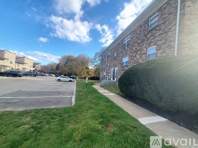 A sunny day at a parking lot with a building in the background.