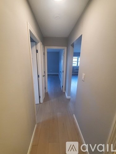 A long hallway with a blue door at the end.