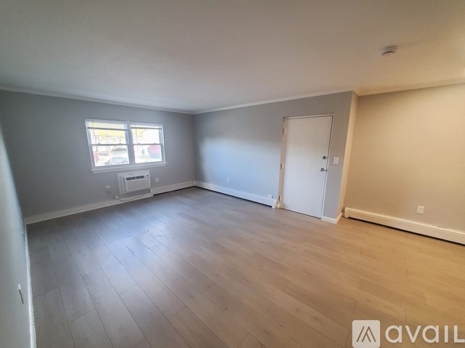 A room with a window and a door is available for rent.