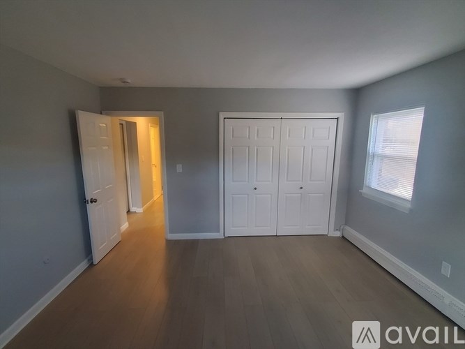 A room with a white door and a window with blinds.