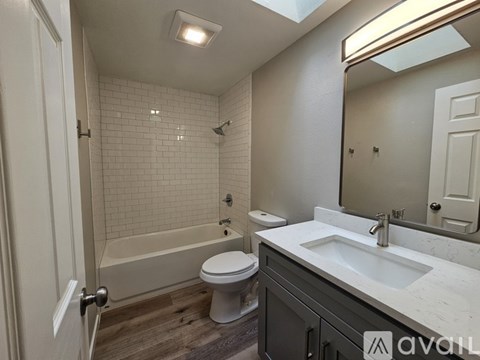 A bathroom with a toilet, sink, and bathtub.