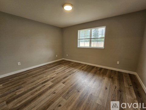 A room with wooden flooring and a window.