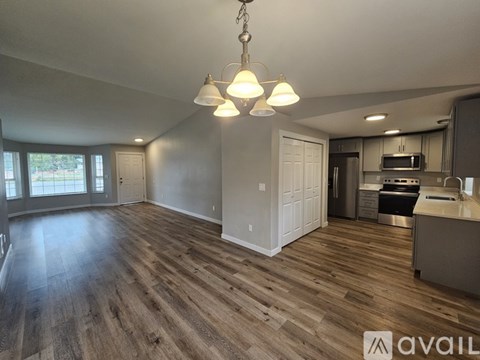 A kitchen with a wooden floor and a large open space.