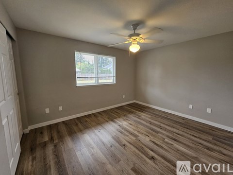 A room with wooden flooring and a ceiling fan.