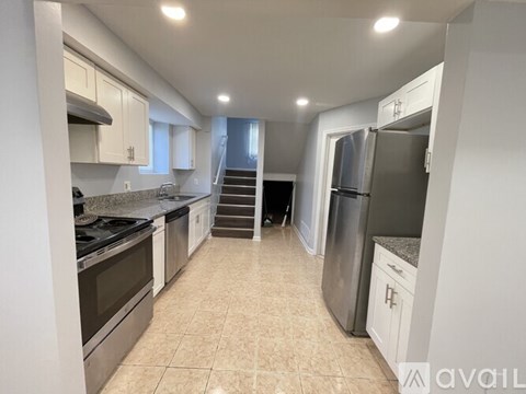 A kitchen with white cabinets and a refrigerator.