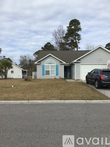 A house with a blue door is in front of a tree.
