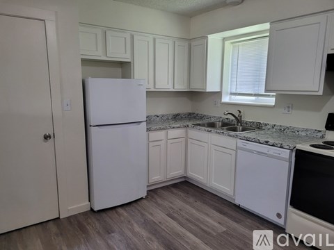 A kitchen with a white fridge and cabinets.